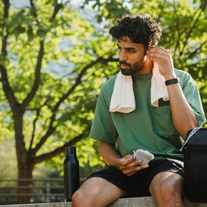 Water bottle and a towel on a wooden bench